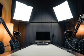 Estúdio moderno de gravação com microfones, iluminação e equipamentos de computador