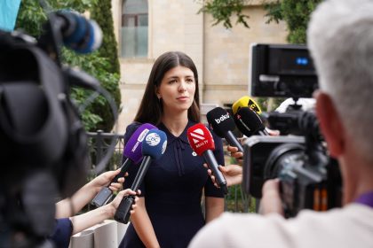 Profissional concede entrevista a jornalistas cercado por microfones durante uma cobertura de imprensa