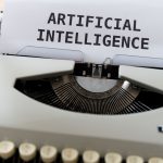 Máquina de escrever com uma folha de papel onde se lê “INTELIGÊNCIA ARTIFICIAL”.