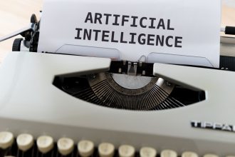 Máquina de escrever com uma folha de papel onde se lê “INTELIGÊNCIA ARTIFICIAL”.