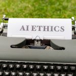 Máquina de escrever antiga com a expressão “AI ethics” escrita em uma folha de papel.