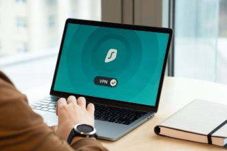 Pessoa usando um aplicativo de VPN em um laptop sobre a mesa de um escritório moderno