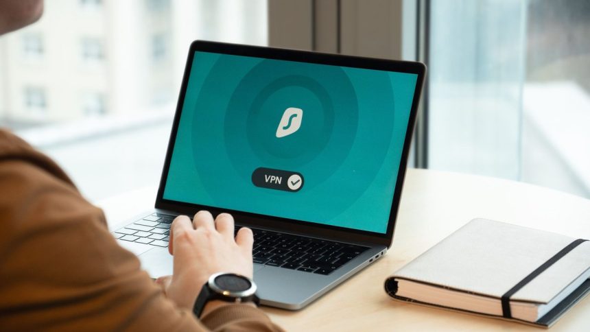 Pessoa usando um aplicativo de VPN em um laptop sobre a mesa de um escritório moderno