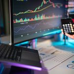 Telas exibem análises e gráficos financeiros em uma estação de trabalho digital.