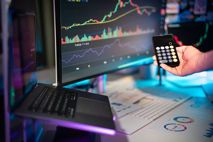 Telas exibem análises e gráficos financeiros em uma estação de trabalho digital.
