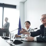 Painelistas participam de uma conferência internacional diante de uma plateia.