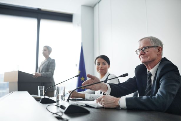 Painelistas participam de uma conferência internacional diante de uma plateia.
